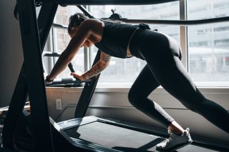 woman in gray tank top and black leggings doing exercise