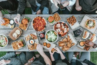 a group of people sitting around a table with food