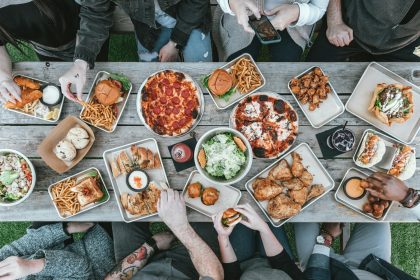 a group of people sitting around a table with food
