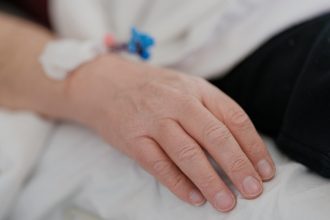 a close up of a person's hand on a bed