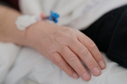 a close up of a person's hand on a bed