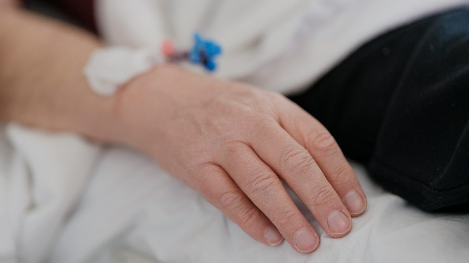 a close up of a person's hand on a bed