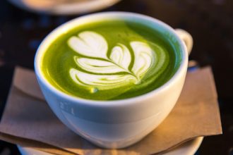 white ceramic teacup filled of matcha tea