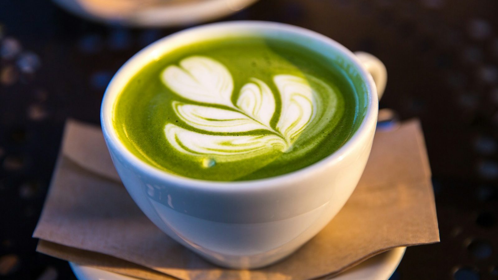 white ceramic teacup filled of matcha tea