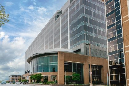 Modern glass building with curved entrance under sky.