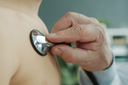 Doctor using stethoscope to examine patient's chest